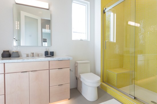 This bathroom in the large home gets its modern aesthetic from clean lines on all the fixtures and finishes, including Gerber's Wicker Park toilet.