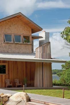 The narrow cedar boards are cut off in a pattern that mirrors the angle of the porch roof while the wider slats are canted in the opposite direction.