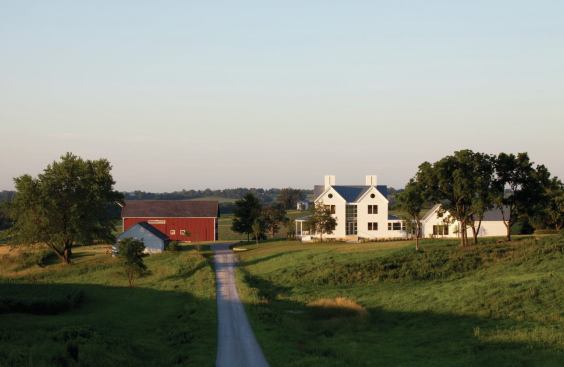 Set on a working farm, the updated farmhouse fits into the rural setting, which includes a restored barn circa 1880.
