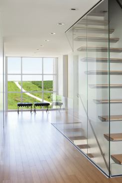 A glassy central circulation spine functions both vertically and horizontally. The transparent stairwell accentuates the openness of the landscape and funnels light into the basement. 