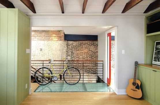 “Pieces of the house that had archeological intrigue,” says Reader, “we made a rule to keep those and clean them up and go from there. Then all of the new elements are white, gray, or green; but we picked up texture or materiality of the old like with bead board.” Pops of color and modern pieces like a glass floor, steel supports and railings, plus a red pocket door contrast the softer hues and old materials.
