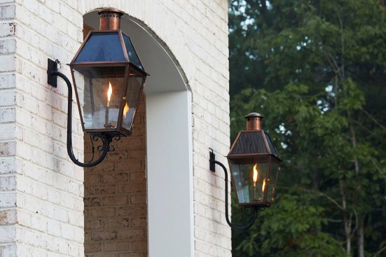 Propane lanterns at the entrance and around the pool help Paragon Building Group design appealing outdoor living areas.