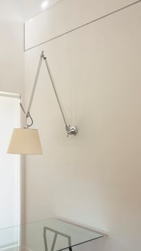 A wall-mounted lamp in the dining area frees up floor space while lending a hip aesthetic.