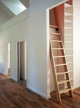 Rather than take up space with a traditional staircase, a ladder provides access to the storage loft.