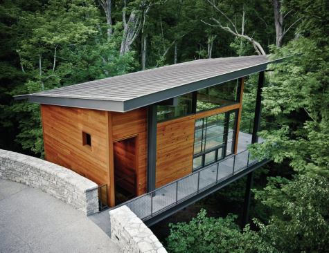 Using the radius of the porte cochere drive, the ceramics and jewelry-making studio breaches the stone wall and perches on four columns.Deep overhangs protect the terrace and allow the studio to expand onto the terrace through the folding window wall.