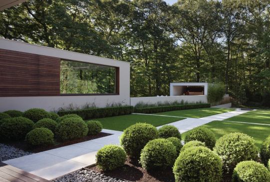 The main house’s stucco and ipe siding are echoed on the kitchen cabana.