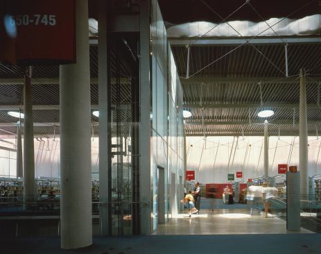 The library’s top floor reading room rises to an exposed tensegrity roof structure.