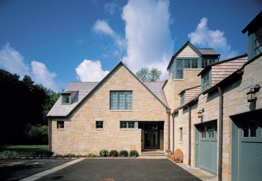 At a limestone-clad house in Highland Park, Ill., an L-shaped plan and a wide front gable help minimize the building's size - a common request from Cohen and Hacker's clients.