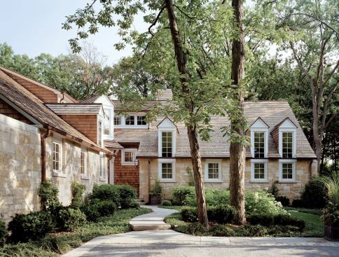 The walls of windows, double-sided glass cabinets, and framed views into other rooms that enrich this Glencoe, Ill., house appear throughout the firm's work. The architects tucked the home's entry into a corner niche, sheltering it from the elements.