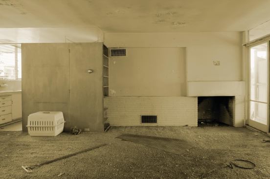 Living room before. Ehrlich forensically reconstructed and refinished built-ins and furniture and restored the fireplace.
