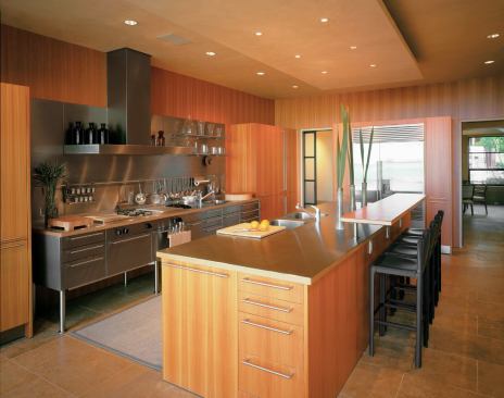 Because the owner wanted only the bare necessities stored around his cooking center, Clark kept things light, with cabinets lifted off the floor. Matching wall panels allow fir cabinetry to fade into the scenery, while stainless cabinets surrounding the c