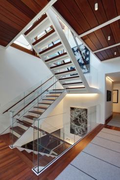 The main stair combines wood, glass, and painted steel.