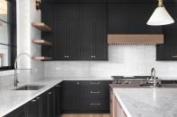 Warm woods and mixed metals add interest in this contrasting black and white kitchen.