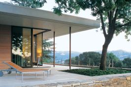 Sliding glass doors open up the corner of the master bedroom to views of the vineyard and mountains beyond. Ample terraces establish a close connection between house and site.